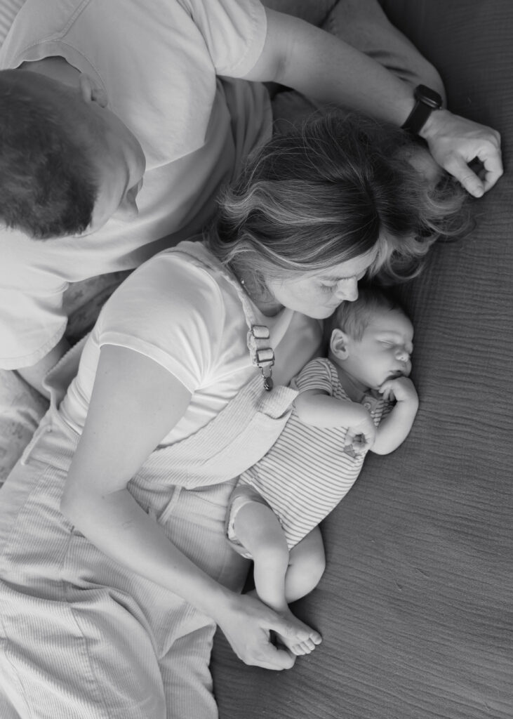 Everyone snuggled on the bed together giving baby kisses