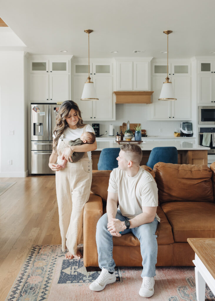 Mom holding baby while dad gazes over admiring her
