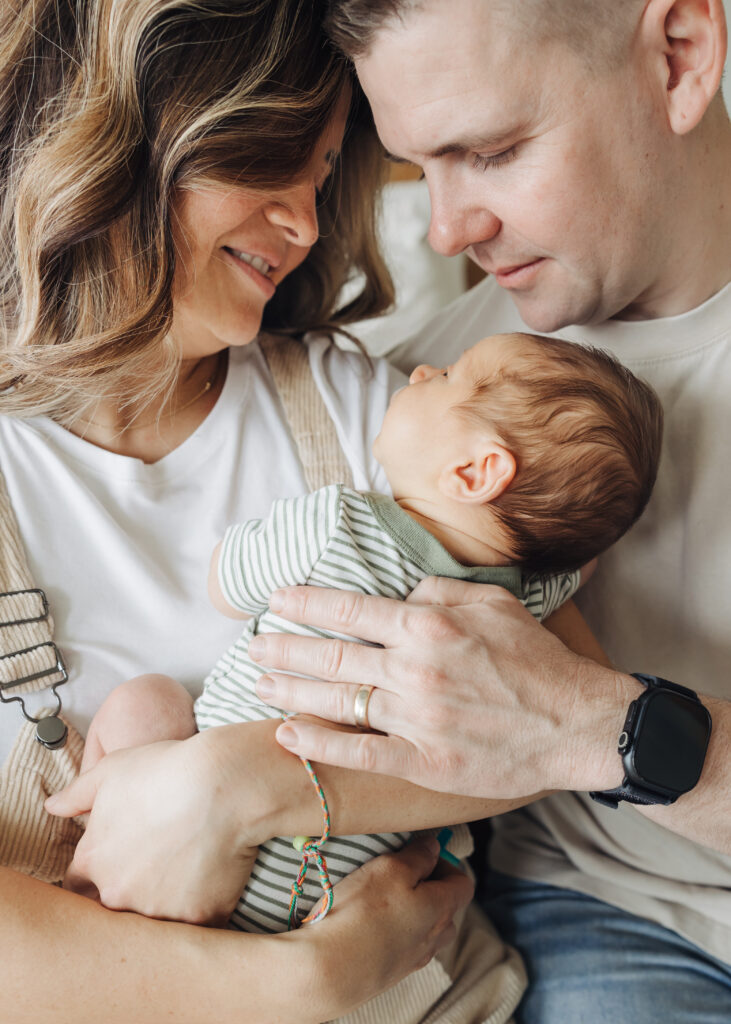 Mom & dad snuggling baby boy with Edmond Lifestyle Newborn Photographer Bailey Griffith Photography